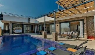 Kalkan Çavdır Köyünde konumlanan içerisinde ısıtmalı iç havuz, jakuzi, sauna, hamama sahip Ultra Lüksk Kiralık Tatil Villası Villa Lalezar üç yatak odalı